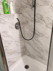 La salle de bains est pourvue d'une douche et d'un mur en marbre blanc. dans l'établissement Ottawa University center near train Station & Parliament, à Ottawa