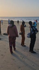 a group of people walking on the beach at Tanji Bco Bird Resort in Tanji