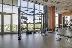a gym with treadmills and machines in a room with windows at Upscale Condo w/ Pool Access in Hyde Beach House! in Hollywood