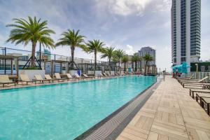 a swimming pool with chaise lounge chairs and palm trees at Upscale Condo w/ Pool Access in Hyde Beach House! in Hollywood