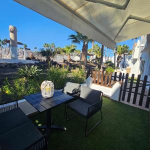 a patio with a table and chairs and a fence at Duna Lagoon in Corralejo