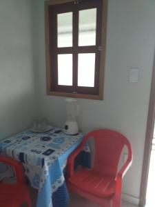 a room with a table and a chair and a window at Kitnet manacá in Paraty