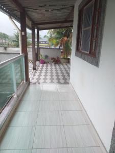 a porch of a house with a tile floor at Kitnet manacá in Paraty