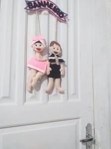 two dolls are hanging on a door at Kitnet manacá in Paraty