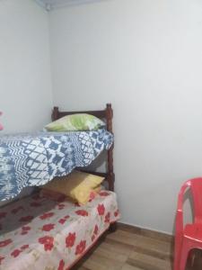 a bedroom with a bed next to a white wall at Kitnet manacá in Paraty