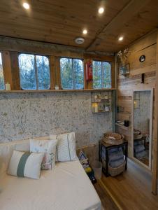 1 dormitorio con 1 cama en una cabaña con ventanas en The Horsebox at Wits End, en Hartford