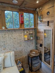 a bedroom of a tiny house with a bed and a mirror at The Horsebox at Wits End in Hartford +7 photos
