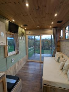 a bedroom in a tiny house with a bed and a tv at The Horsebox at Wits End in Hartford
