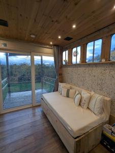 a large bed in a room with a large window at The Horsebox at Wits End in Hartford