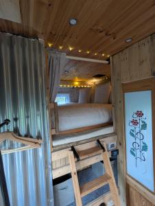 a bedroom in a trailer with a bed and a ladder at The Horsebox at Wits End in Hartford