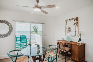 Un comedor con una mesa de cristal y sillas. en Guana Beach Inn, en Great Guana Cay