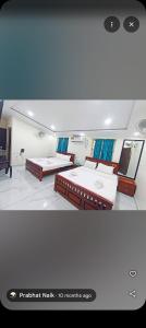 een slaapkamer met twee bedden in een kamer bij Flora inn in Ankola