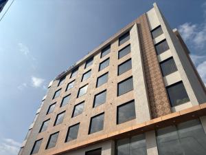 a tall building with a blue sky in the background at Hotel Amyra in Kota