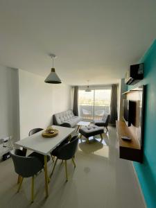 a living room with a table and chairs and a couch at Comfort and spectacular views in Barranquilla! in Barranquilla
