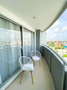 two chairs on a balcony with a view of the city at Comfort and spectacular views in Barranquilla! in Barranquilla