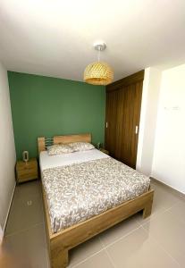 a bedroom with a bed and a green wall at Comfort and spectacular views in Barranquilla! in Barranquilla