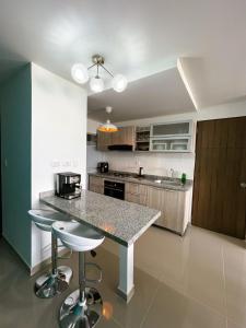 a kitchen with a counter and stools in a room at Comfort and spectacular views in Barranquilla! in Barranquilla