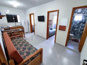 a living room with a couch and a bathroom at Pousada Pegadas na Areia in Palhoça