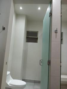 ein Badezimmer mit Toilette und Glasdusche in der Unterkunft Avenir Armonia Suites in Rincón de Guayabitos + 41 Fotos