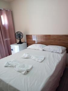 ムクジェーにあるPousada Recanto da Vilaの白いタオルが2枚敷かれたベッド