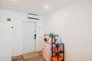 una habitación con un refrigerador rosa y una puerta blanca en Guana Beach Inn, en Great Guana Cay
