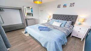Un dormitorio con una cama grande con una manta azul. en Sandbanks Braunton, Stylish Cottage near to Saunton Beach Sleeps 4, en Croyde 10 fotos más