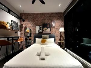 a large bed in a room with a brick wall at Scarletz suites klcc Twin Tower by ESD in Kuala Lumpur +79 photos