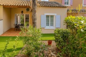 a house with a yard with a tree and a patio at Domaine de Fayence in Fayence