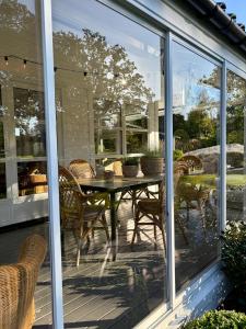 SørvågにあるStylish Villa - Boat, Greenhouse & Majestic Oaksのテーブルと椅子が置かれた網戸付きのポーチ