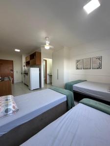 Zimmer mit 2 Betten und einer Küche mit Kühlschrank in der Unterkunft Morada da Fé I 300 m da Canção Nova Cond Da fé in Cachoeira Paulista