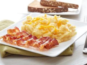 アレクサンドリアにあるFairfield Inn & Suites by Marriott Alexandria West/Mark Centerのテーブルの上にワッフルとチーズが乗った料理の皿