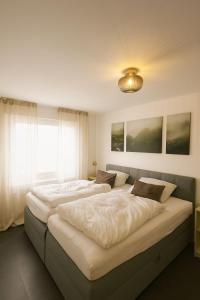 2 camas grandes en un dormitorio con ventana en Ferienwohnung Fischer, en Stolberg