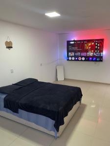 a bedroom with a bed and a tv on the wall at Apartamento espaçoso e bem localizado in Boa Vista