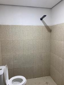 a bathroom with a white toilet and a light on the wall at Apartamento espaçoso e bem localizado in Boa Vista
