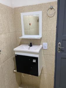 a bathroom with a white sink and a mirror at Apartamento espaçoso e bem localizado in Boa Vista +4 photos