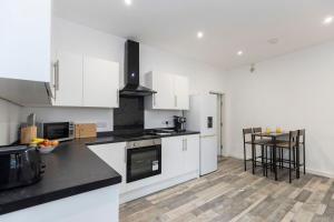 a kitchen with white cabinets and a table in it at *Discounts/Contractors/WIFI/Free Parking/Smart TV in Durham