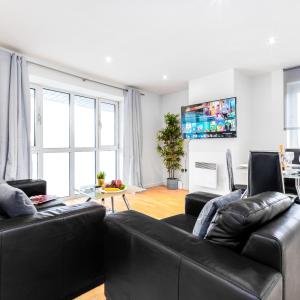 ein Wohnzimmer mit zwei schwarzen Ledersofas in der Unterkunft Stylish Two Bed Apartment - Speed Wi-Fi - Smart Tv - Parking 201MH in Birmingham