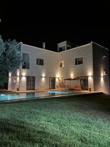 a large white building with a swimming pool at night at Suites white house in Essaouira