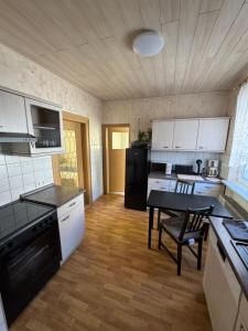 a kitchen with white cabinets and a table in it at Ferienhaus WorkersParadise in Elxleben