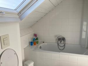 a bath tub in a bathroom with a skylight at B&B Haus Jola in Nidrum
