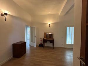 ein leeres Wohnzimmer mit einem Tisch und einem Spiegel in der Unterkunft Vista Verde - Villla Giulia 5 min loopafstand tot het meer in Porto Valtravaglia