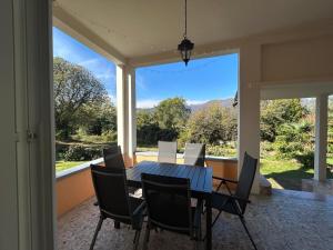 ein Esszimmer mit Tisch und Stühlen und einem großen Fenster in der Unterkunft Vista Verde - Villla Giulia 5 min loopafstand tot het meer in Porto Valtravaglia + 27 Fotos