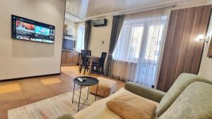 Una sala de estar con un sofá y un televisor de pantalla plana. en Kyiv Center Romantic Apartment, en Kiev