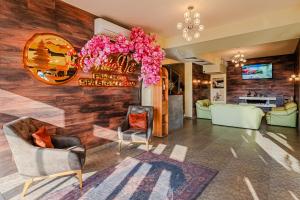 a lobby with chairs and a sign on the wall at ArdoVel Park Hotel in Velingrad