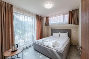 a bedroom with a bed and a large window at ArdoVel Park Hotel in Velingrad