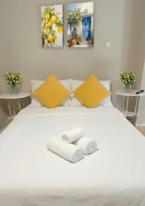 a bedroom with a white bed with two towels at Casa de Limón - סוויטות בוטיק וספא יוקרתיות בגליל העליון in Sede Eli‘ezer