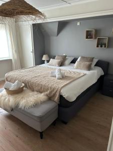 a bedroom with a large bed and a window at De Bijenkorf in Damme