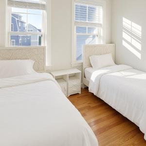 two beds in a white room with two windows at Adam's apartment Modern 3BR 2BA Free Parking by Swampscott Beach By Amana Green realty in Swampscott