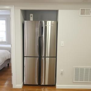 a stainless steel refrigerator in a living room at Adam's apartment Modern 3BR 2BA Free Parking by Swampscott Beach By Amana Green realty in Swampscott