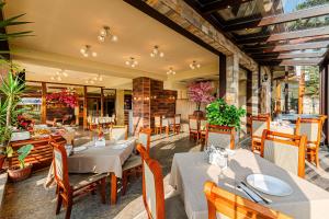a dining room with tables and chairs and a restaurant at ArdoVel Park Hotel in Velingrad